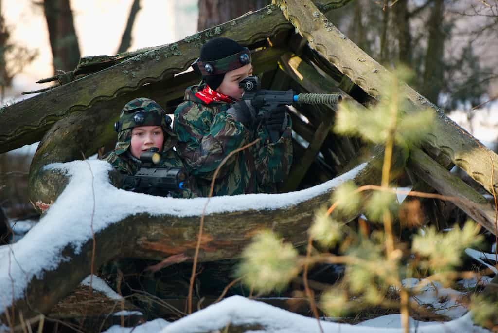 2 kids playing laser tag game on a snow playground